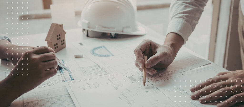 Architects reviewing contract documents and blueprints for project planning and risk management.