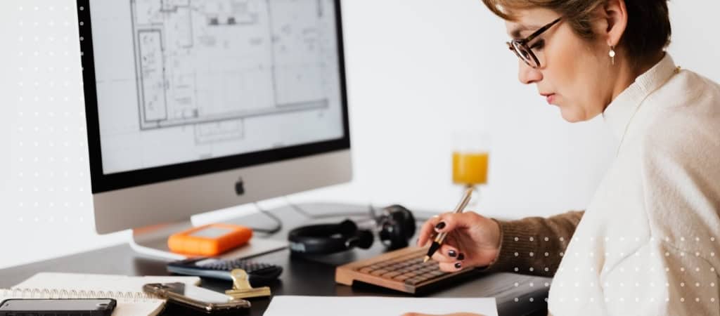 Architect reviewing contract details on computer for project protection.