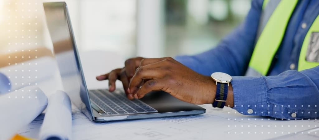 Construction professional using a laptop for contract management and project planning.