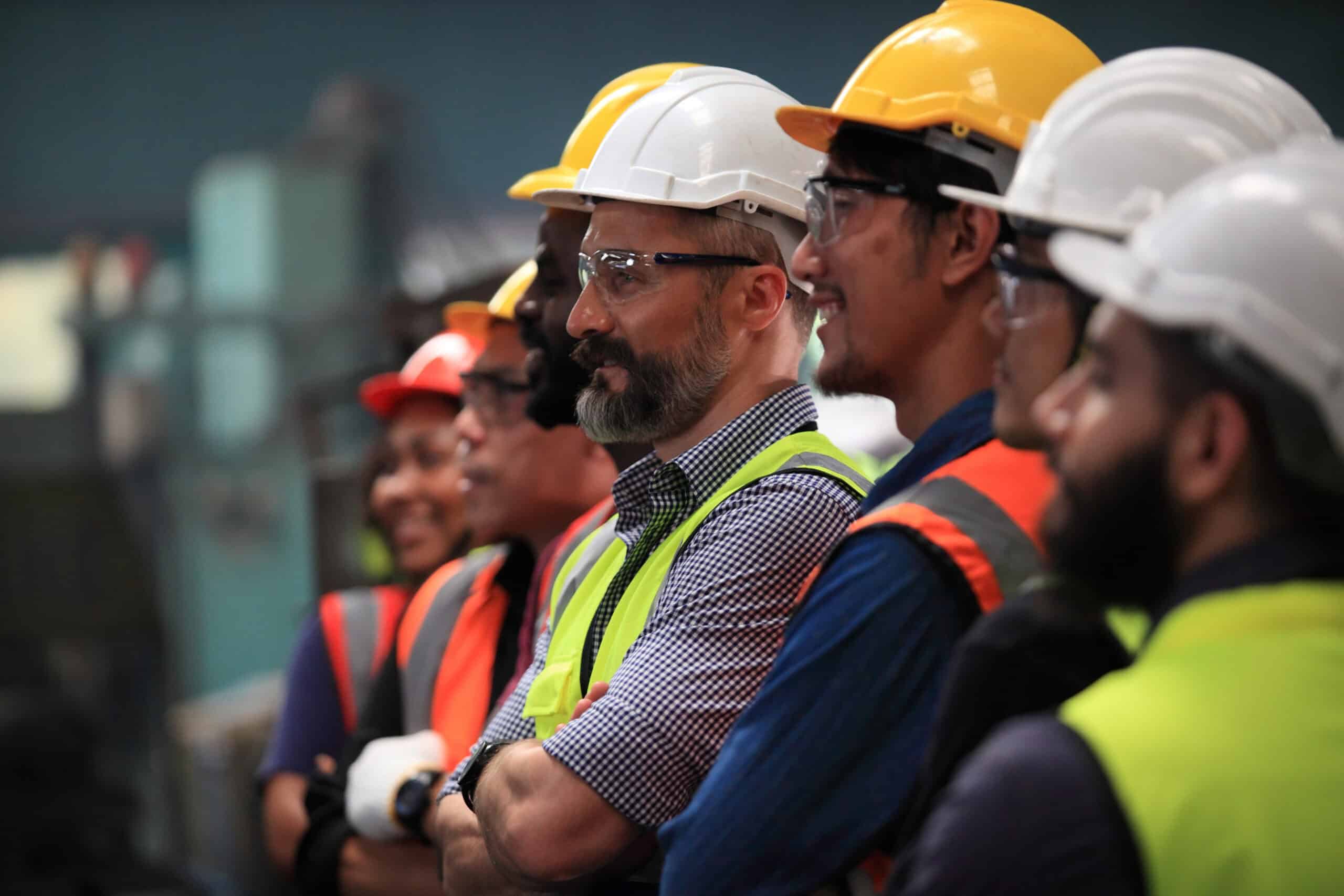 Construction workers in safety gear at a work site.