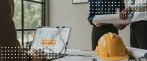 Laptop open to a contract selection screen beside a hard hat, the first step in choosing an AIA contract document.