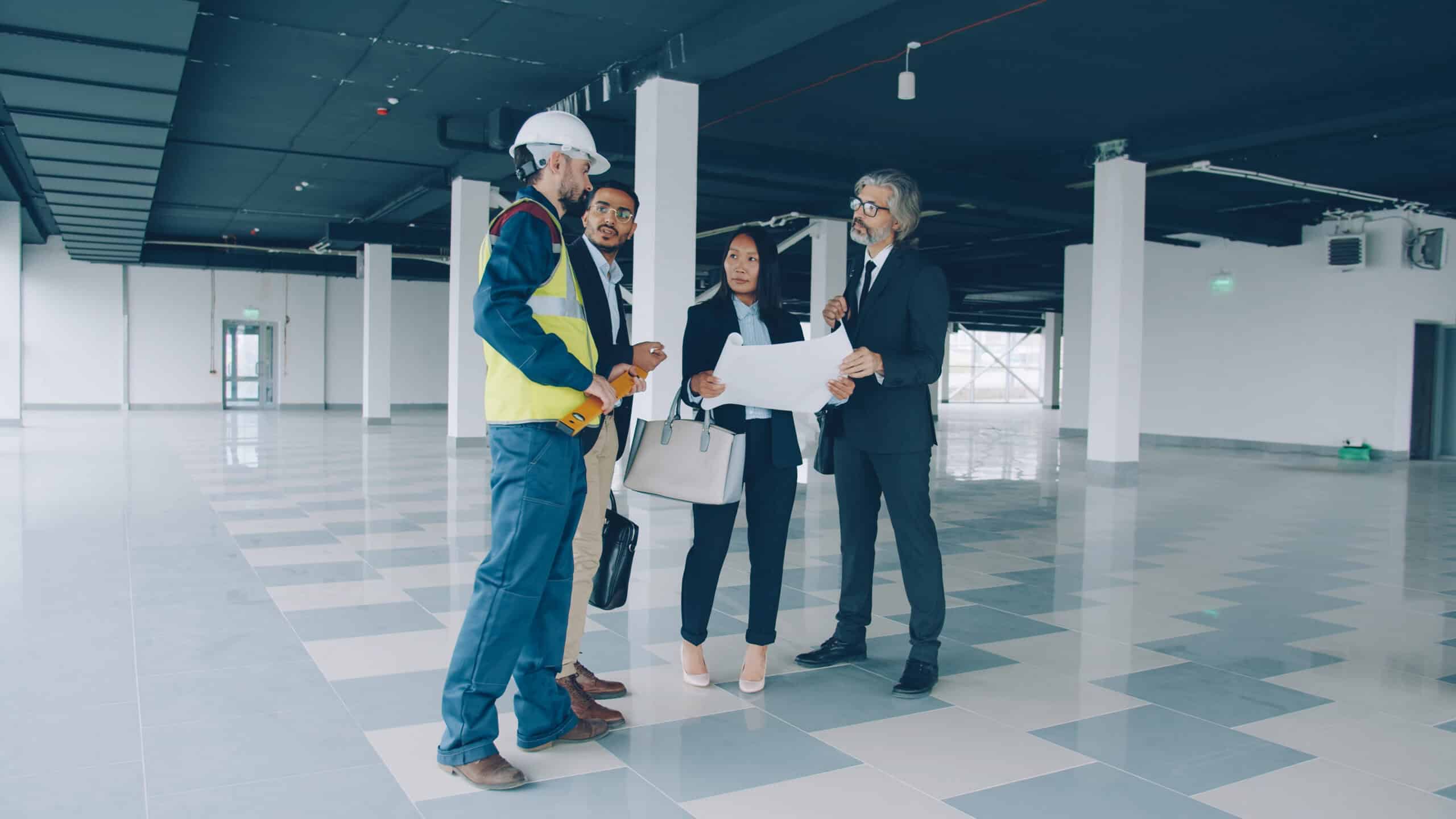Business professionals discussing plans at a construction site.