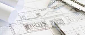 Blueprints, rolled plans, and a pen on a desk, the drawings construction contracts for architects are built around.