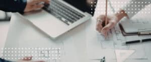 An architect drafts on paper beside a laptop, the design work architect contract documents define.